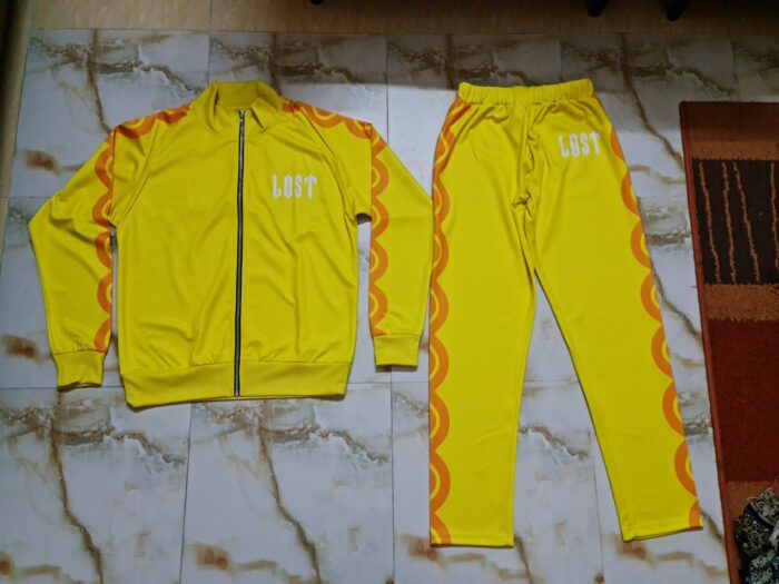 A vibrant yellow tracksuit displayed on a hanger, featuring a comfortable fit and stylish design, ideal for workouts or casual wear.